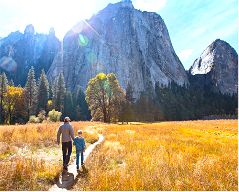 Father and son walking through Yosemite Valley in the Fall